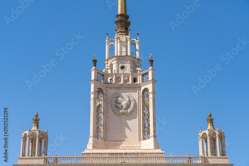 The gilded pointed pentagram tower of the Beijing Exhibition Center stands against a blue sky background