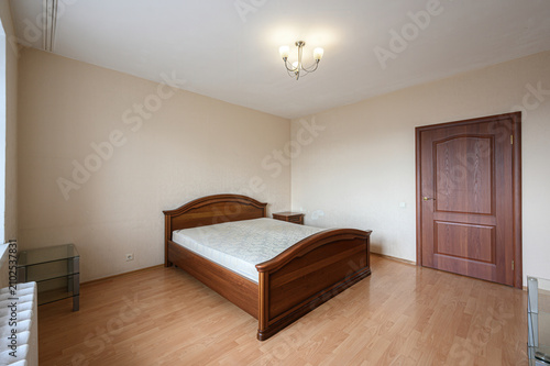 Konstfotografi neat bedroom features a wooden double bed with curved headboard, glass bedside t