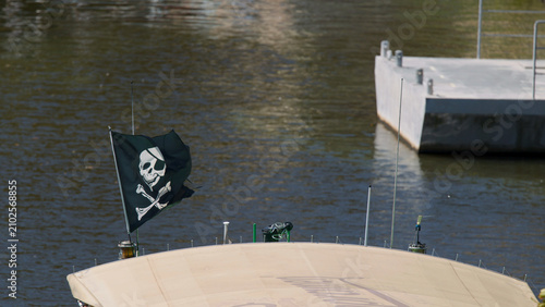Quadro su tela Pirate Flag Waving on Boat Bow Over Vltava River in Prague