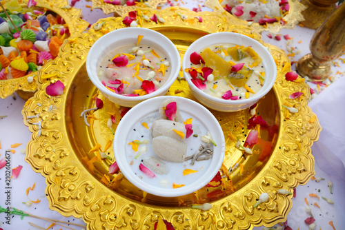 Thai religious or spiritual offering setup, featuring traditional Thai coconut-milk desserts served on gold tray and garnished with flower petals. Symbolizing blessings, prosperity, and good fortune