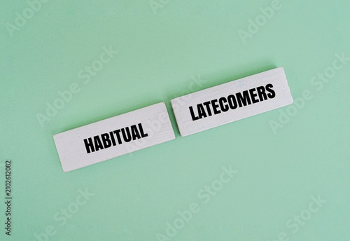 Принти на полотні Wooden blocks with the text HABITUAL LATECOMERS on a green background