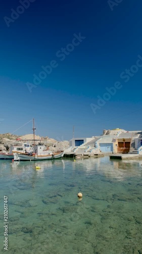 Mandrakia village Milos in Greece, where charming fishing boats sway gently in the turquoise waters. The vibrant village by the shore adds to the idyllic holiday atmosphere