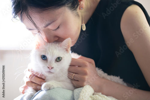 白猫を愛おしそうに撫でる女性