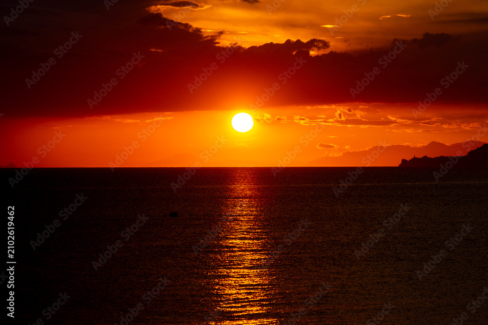 Fototapeta premium Dramatic Sunset Over Calm Water With Colorful Evening Sky