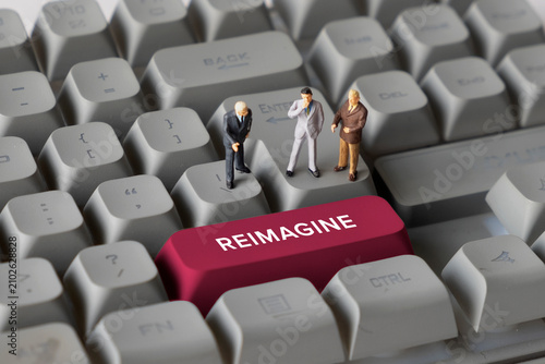 Innovation and business reimagination concept with small figurines standing on keyboard