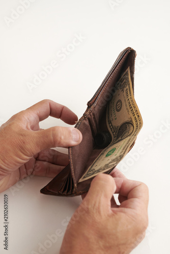 Hand Taking the Last Dollar from an Almost Empty Wallet