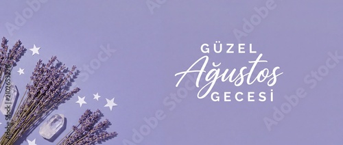 Lavender flowers with quartz crystal on purple banner background. Turkish text Güzel Ağustos Gecesi, stars, botanical summer night flat lay composition for wellness, esotericism, and aromatherapy.