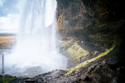 Cuadro en lienzo n Iceland there is a waterfall where people can walk behind it on a path
