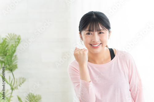 Foto ガッツポーズするヨガウェアの若い女性