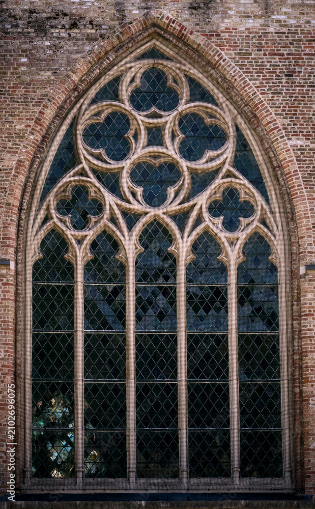 Obraz premium Intricate Gothic Tracery Window of a Historic Brick Building