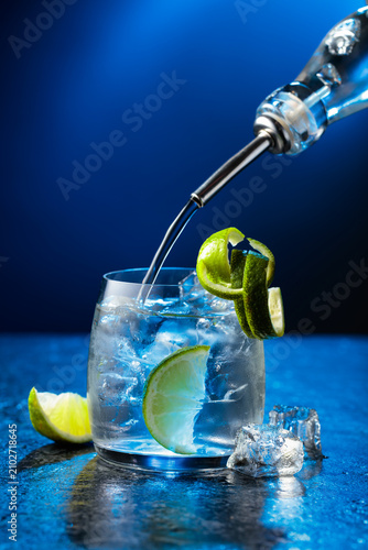Canvas Print Vodka with lime and ice cubes in a fogged up glass.