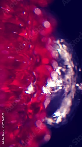 Vertical A pile of red marbles underwater, with water gushing up due to water pressure.