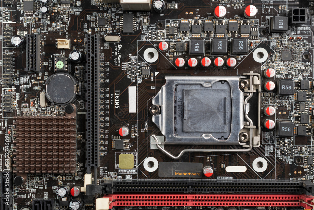 Fototapeta premium Close-up top view of a computer motherboard with CPU socket, electronic components, and circuits.