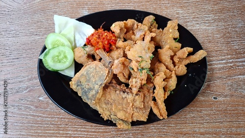 Gurame Saos Telur Asin. Crispy fried gourami fish covered with salted egg sauce. Indonesian food