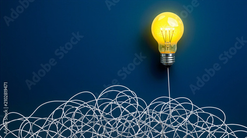 Glowing light bulb rising from tangled messy wire, creative problem solving concept, finding a simple solution to a complex business challenge