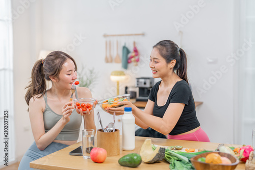 Woman kitchen vegetable fruit healthy meal home food friend smile Two woman preparing healthy meal together in bright home kitchen with fresh vegetable, fruit, drink, cheerful smile