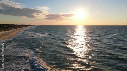 Aerial view of a sandy beach with dunes at golden sunset