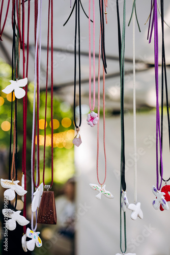 Handmade ceramic pendant necklaces displayed for sale at a local artisan market.