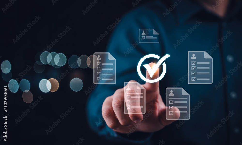 Fototapeta premium Businessman working on laptop with virtual screen, document with checkbox and checkmark, online survey, checklist concept.