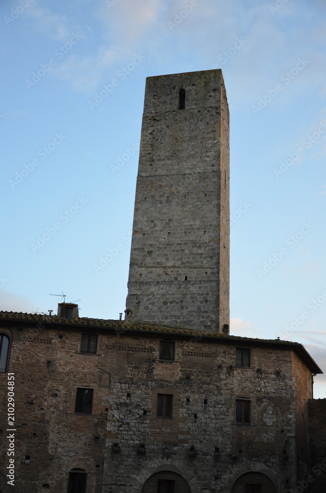 Obraz premium San Gimignano, Italy 03.04.2020: Town Hall (also known as the Palazzo del Popolo or Palazzo Nuovo del Podestà) and the Torre Grossa in San Gimignano