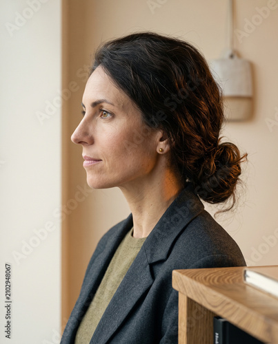 Close-up profile of a confident business leader, embodying understated elegance. Editorial portrait emphasizing natural light, sophisticated textures, and the Quiet Luxury of expert presence.
