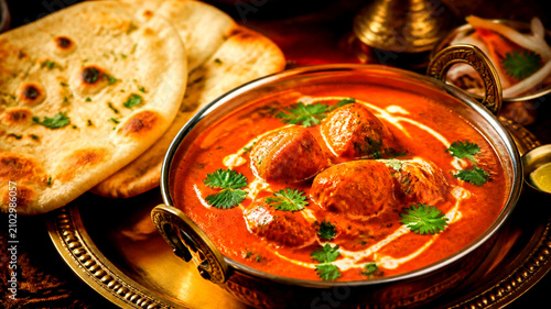 Flavorful Chicken Meatballs in Rich Tomato Curry Sauce with Fresh Herbs and Warm Naan Bread