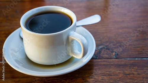 Foto Warm morning tea served in a white ceramic cup with spoon on a rustic wooden table
