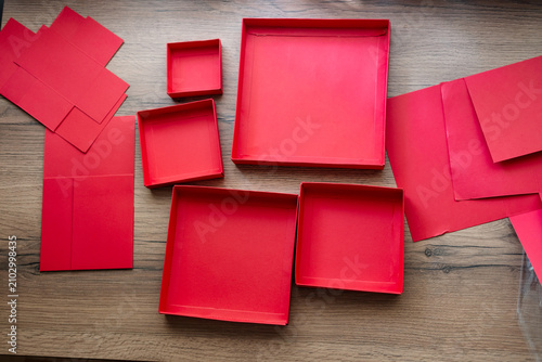 Принти на полотні Lids from a red collapsible gift box gathered on a wooden table