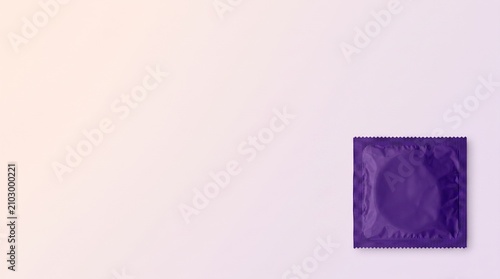 Single purple condom in a wrapper on pastel background