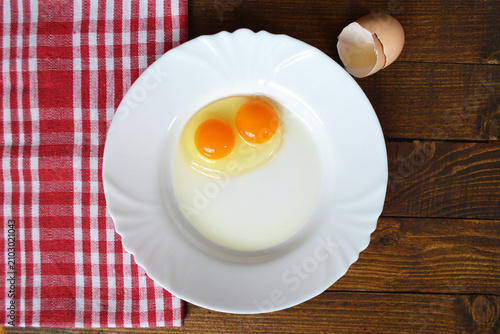 Raw double-yolk egg on the plate