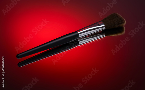 Makeup Brush Resting on Reflective Surface with red Gradient Background