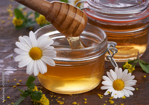 jar of honey and chamomile flowers