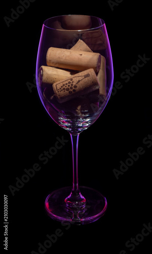 Wine Glass Filled with Corks in Dramatic Purple Light