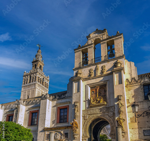 Side gate to Seville's Cathedral with its iconic bell tower (Giralda) in the background, Seville (Sevilla), Andalusia (Andalucia), Spain