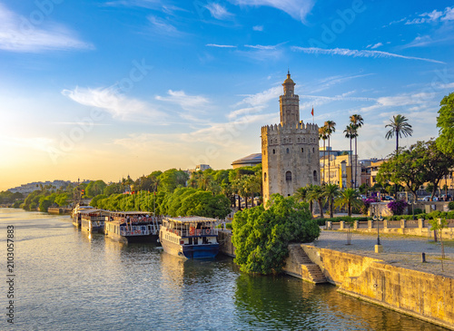 Sightseeing boats on the Guadalquivir river with the iconic Torre del Oro tower in the background,.Seville, Andalusia, Spain