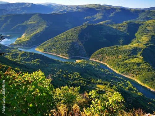Stunning panoramic view from the Kozji Kamen (Goat Rock) viewpoint overlooking the winding Lake Zavoj (Zavojsko jezero), surrounded by the scenic slopes of Stara Planina.  Beautiful landscape view