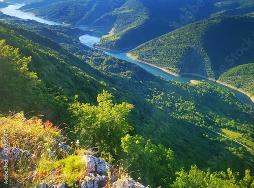 Stunning panoramic view from the Kozji Kamen (Goat Rock) viewpoint overlooking the winding Lake Zavoj (Zavojsko jezero), surrounded by the scenic slopes of Stara Planina.  Beautiful landscape view