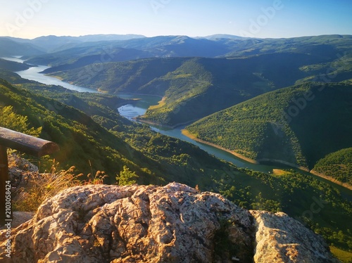 Stunning panoramic view from the Kozji Kamen (Goat Rock) viewpoint overlooking the winding Lake Zavoj (Zavojsko jezero), surrounded by the scenic slopes of Stara Planina.  Beautiful landscape view