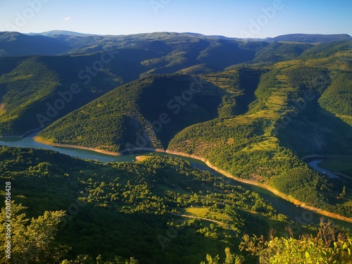 Stunning panoramic view from the Kozji Kamen (Goat Rock) viewpoint overlooking the winding Lake Zavoj (Zavojsko jezero), surrounded by the scenic slopes of Stara Planina. Beautiful landscape view 