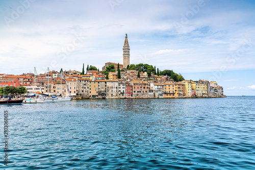 Photography Rovinj, Croatia, with colorful old town buildings, church tower, boats and calm Adriatic Sea in a scenic summer waterfront view
