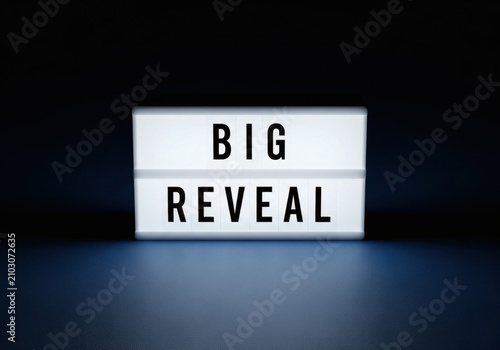 Big Reveal text on glowing cinema lightbox in dark blue background