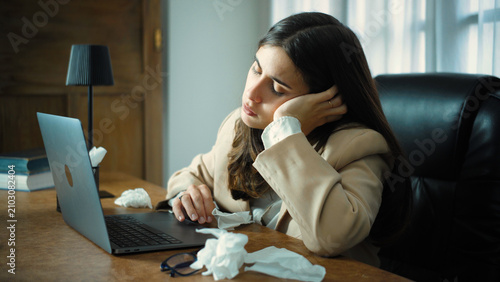 Fényképezés Young Hispanic businesswoman in her office feeling extremely exhausted and physically unwell, struggling with fatigue and discomfort during her workday in a modern workplace