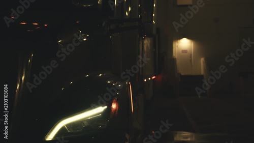 Commercial semi-truck idling at a loading dock at night