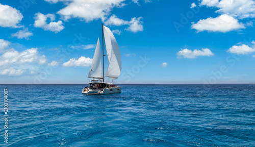 Luxury travel white sailboat yacht cruising deep sea horizon clouds sky calm water perfect idyllic summer weather. Nautical adventure freedom lifestyle background, ocean voyage wind sailing regatta