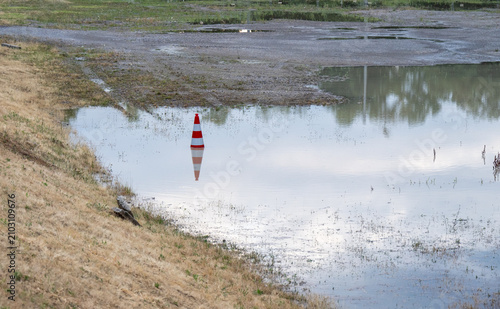 Fotografía Nach einem Gewitter hat sich an einer Baustelle eine große Pfütze gebildet
