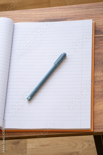 Foto Open blank notebook with pen on wooden desk