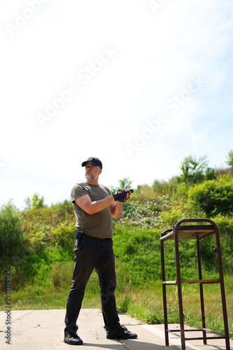 фотографія Outdoor shooting range instructor demonstrating firearm operation with focus on safety, precision and responsible handling