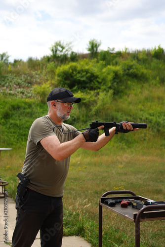 Foto Experienced shooting coach demonstrating safe firearm handling and marksmanship skills in an outdoor training environment