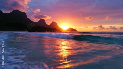 Beautiful tropical beach sunset with mountains and purple clouds