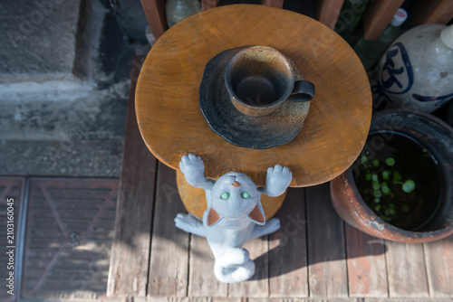Climbing cat on table with coffee cup at cafe in Yanaka Ginza, Tokyo